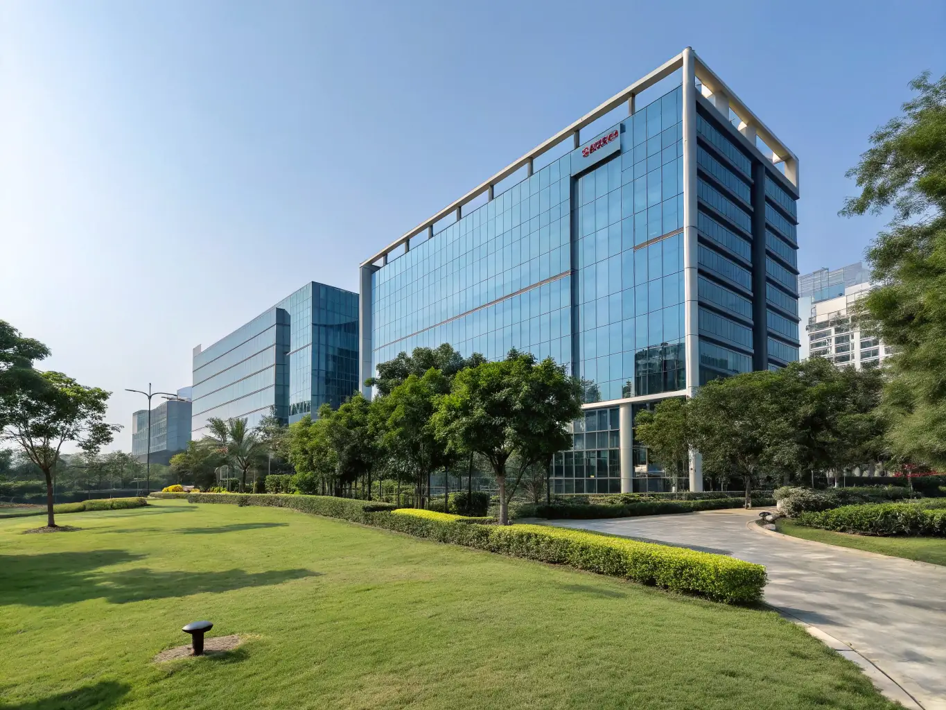 Exterior of SGV Holdings office in Gurugram, India, situated on Golf Course Road, surrounded by lush greenery and commercial buildings.